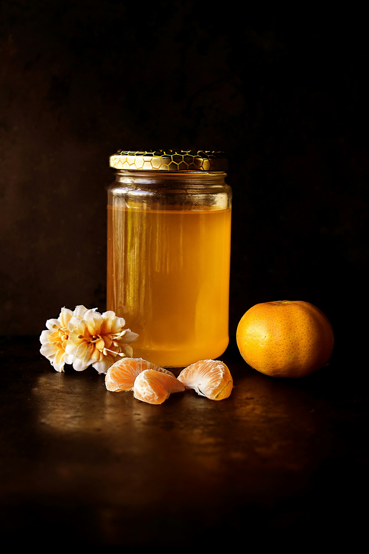 Glass jar of golden condiment in warm low light