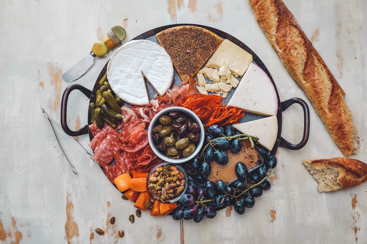 Charcuterie board with sliced salami, cured meats, cheeses, and cornichons