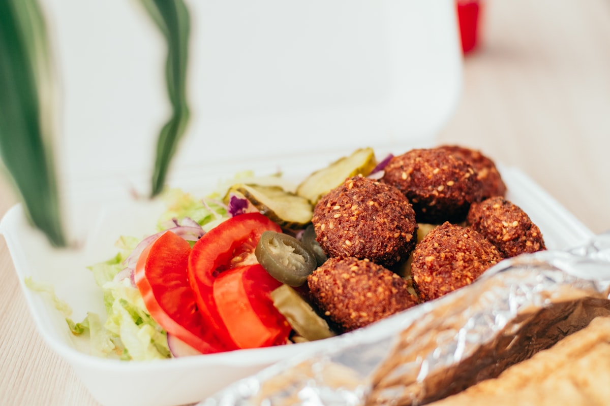 Prepared foods with salad and pickles in a to-go container
