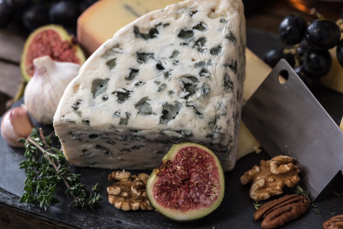 Holiday cheese board with blue cheese, figs, grapes, and walnuts